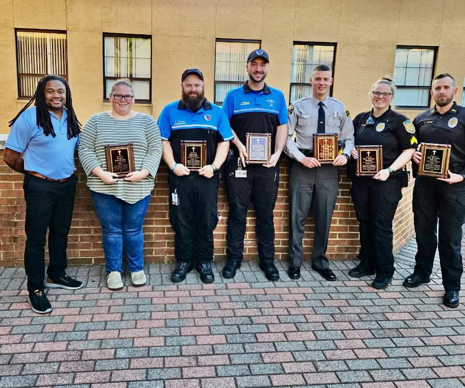 Group of school staff and officials holding plaques during school projects update.