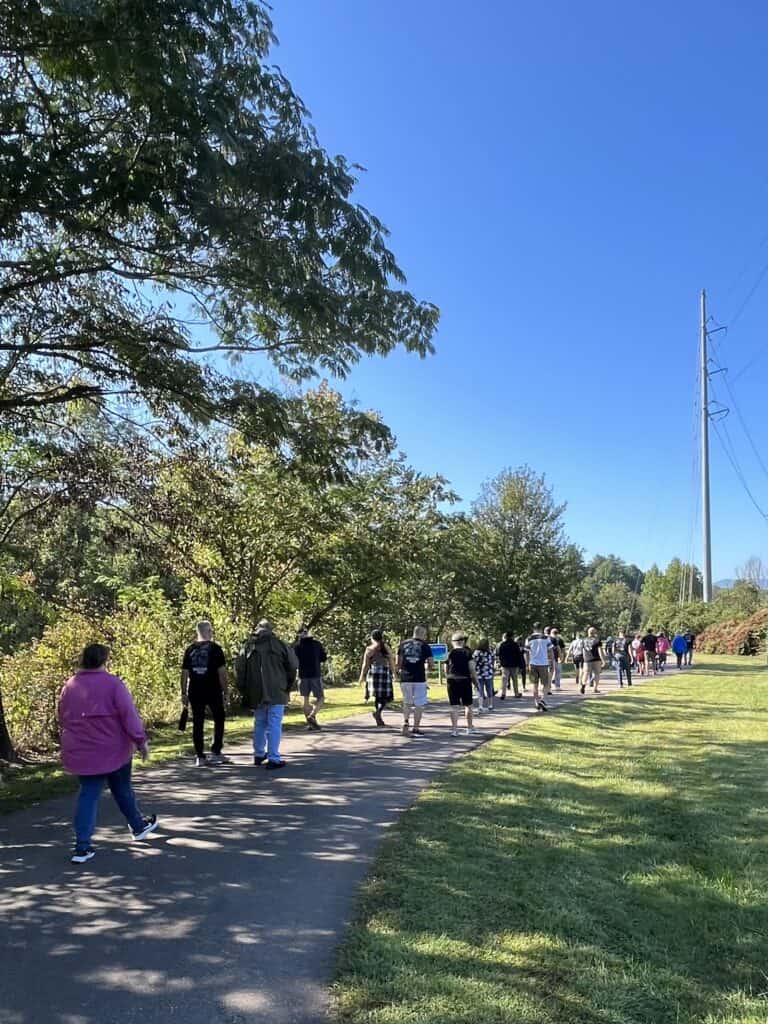 Group of veterans and community members walking outdoors on a sunny day.