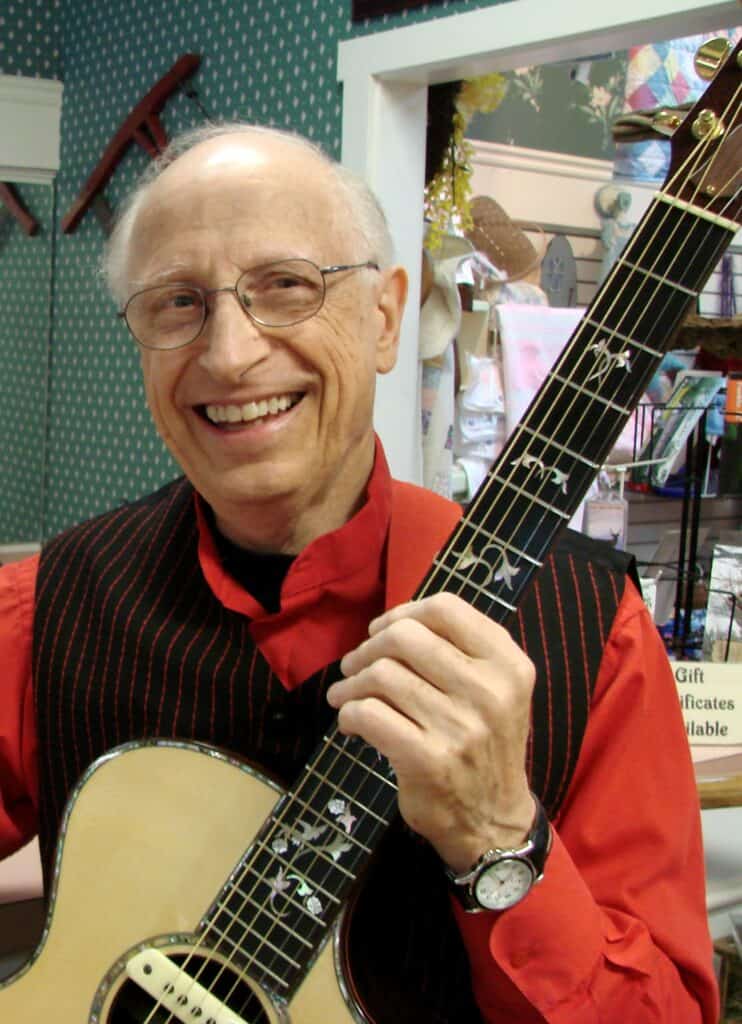 Local music icon Ronnie Evans with guitar, showcasing his enduring musical talent.