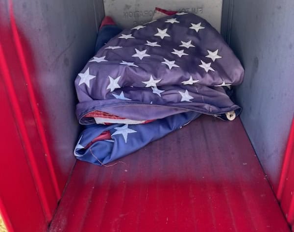American flag blanket folded in a red mailbox, honoring veterans on Veterans Day.