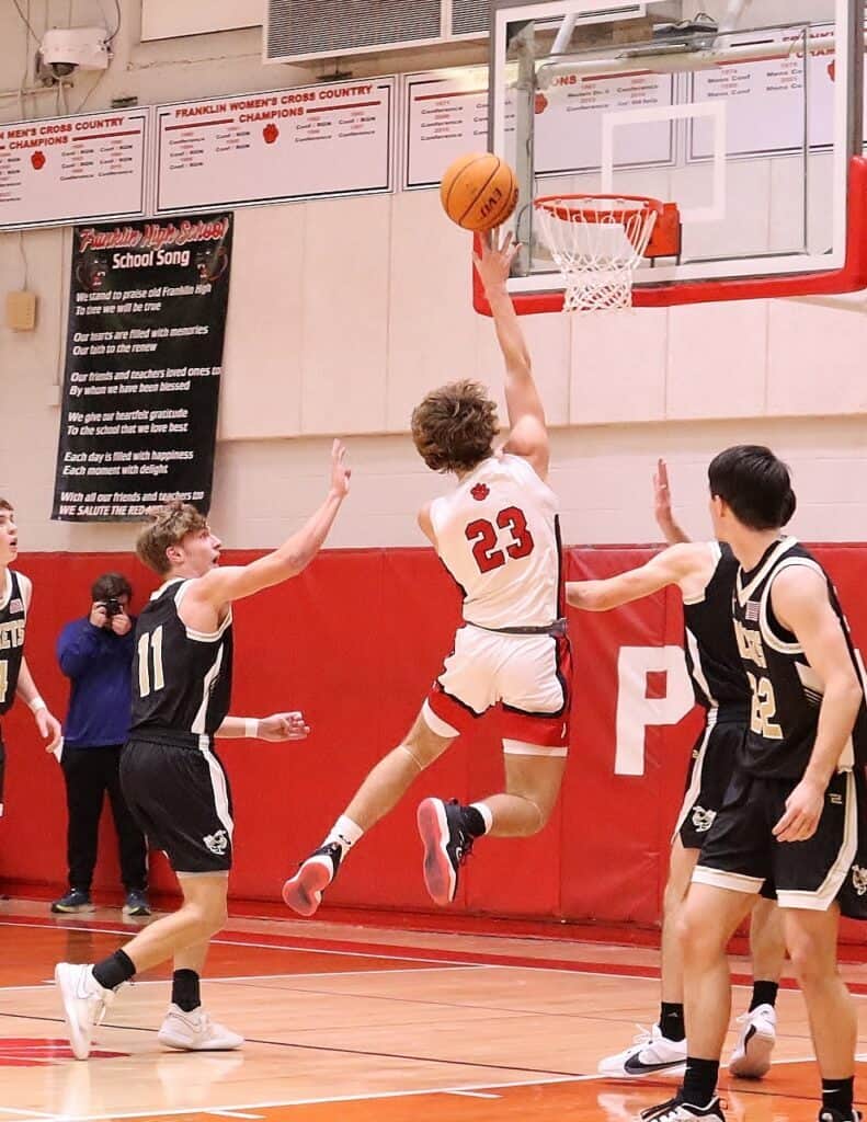 Basketball player in white jersey #23 jumps for a shot during a game at FHS.