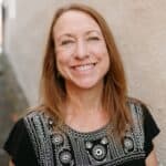 Woman smiling, showing gratitude for kindness and giving.