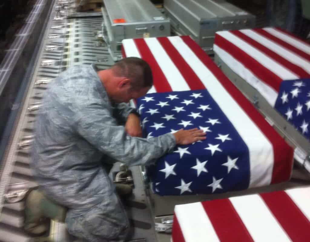 Veteran working on American flag casket in a manufacturing facility.
