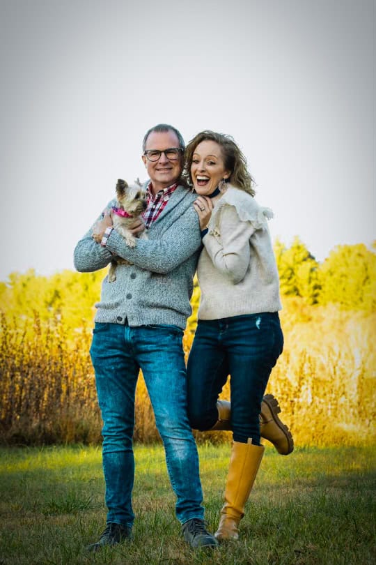 Happy couple embracing outdoors in a field with yellow flowers, celebrating love in Macon County.