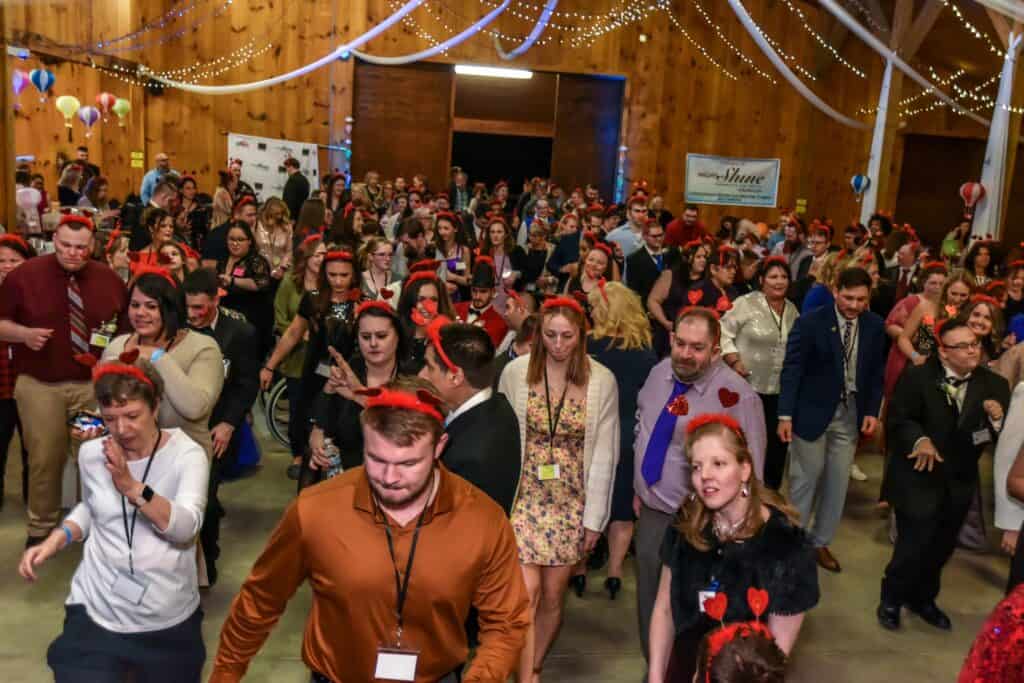 People dancing at Night to Shine event in a decorated hall.