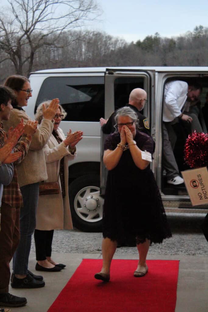 Woman emotional at Night to Shine event, surrounded by supporters.