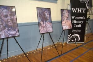 Art display of sculptures honoring women of Macon County at unveiling event.