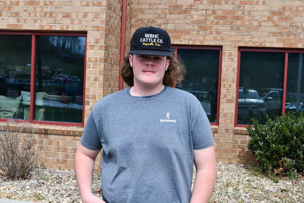 Young voter at campaign event wearing "WBHC Cattle Co." cap.