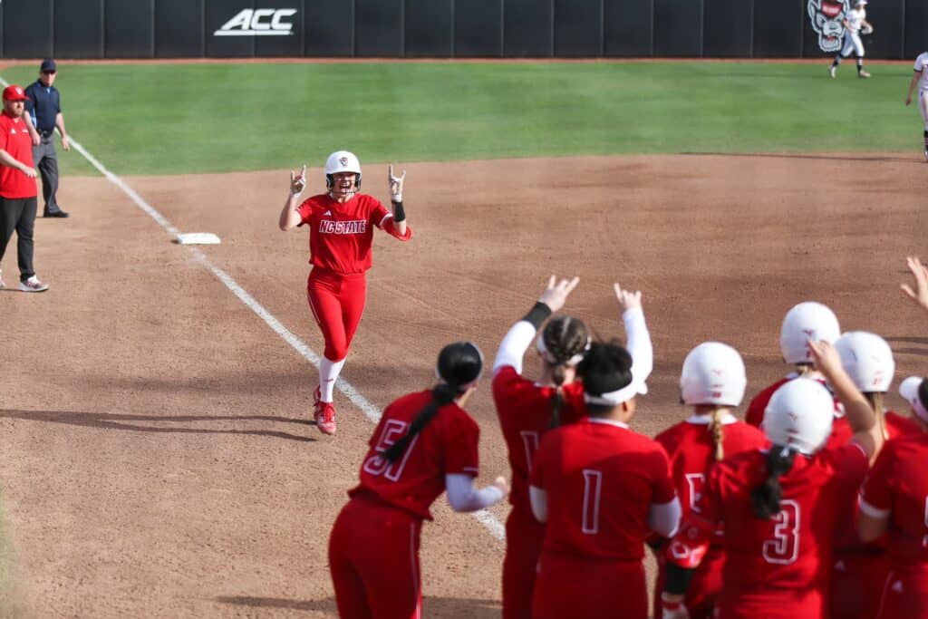 NIL deal signing at FHS baseball game featuring former athletes in red uniforms.