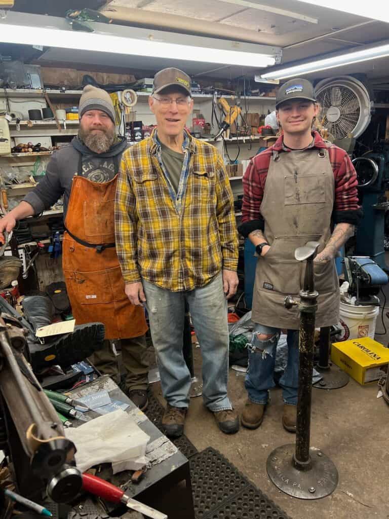 Skilled cobblers fixing shoes in a workshop with tools and equipment.