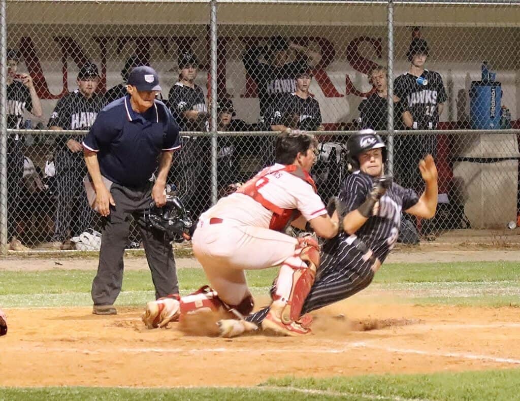 Softball player sliding into home during a game, breaking records.