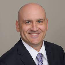 Smiling man in a suit representing financial planning for education savings.