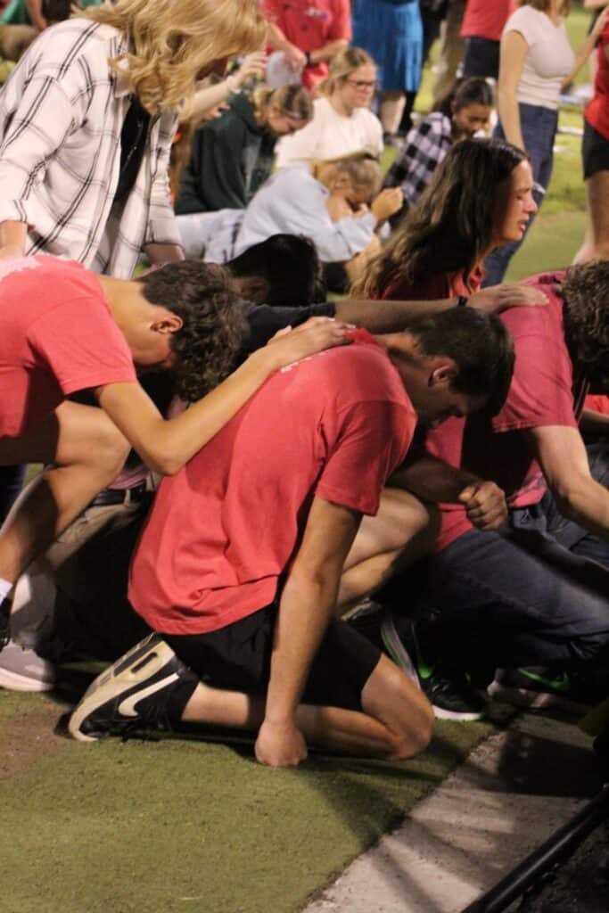 Young people praying during the Fields of Faith event at Macon Sense.