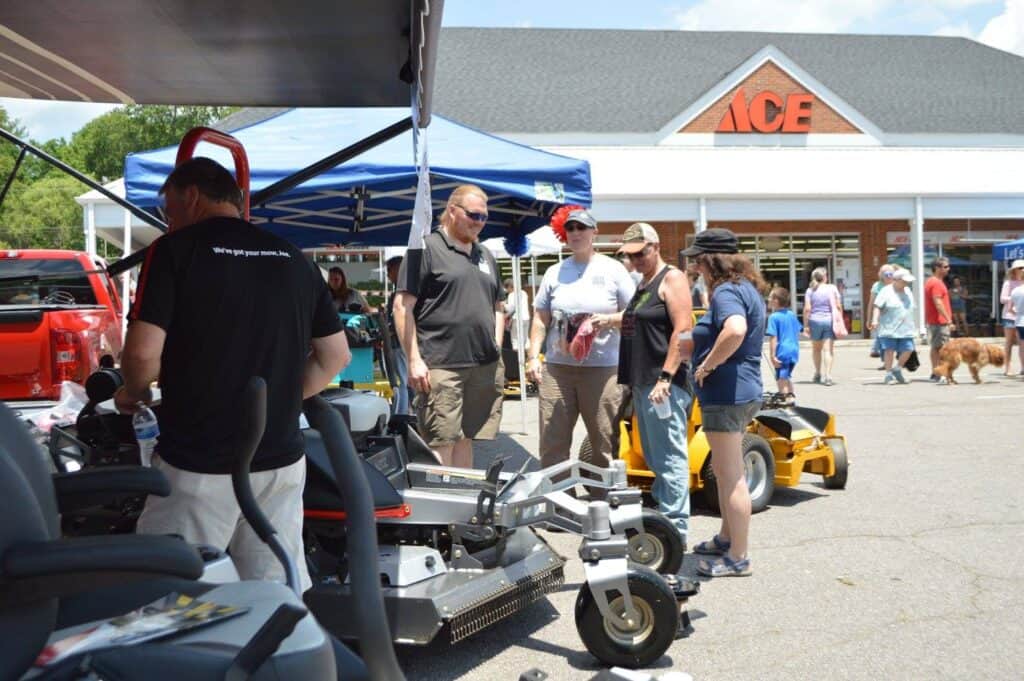 Customers exploring outdoor power equipment at Ace Hardware event in Macon.