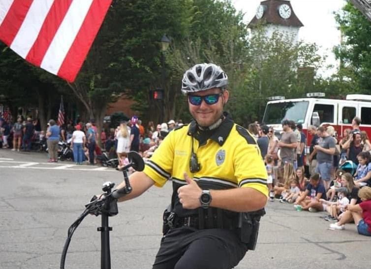 Police officer on e-bike at community event in Macon Sense.