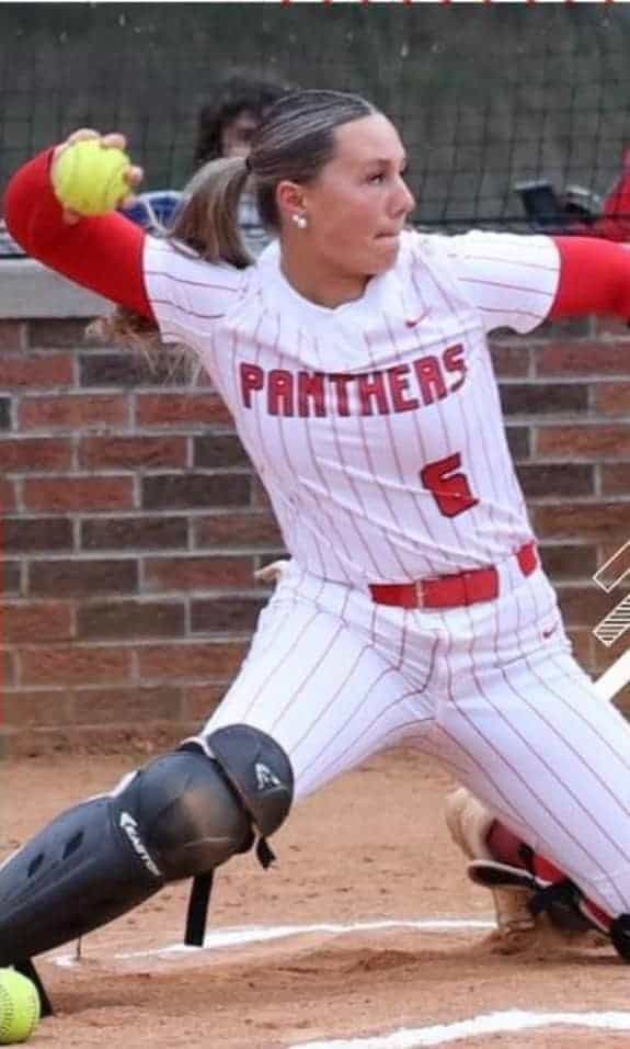 Female softball player in action during a game, wearing a Panthers uniform.