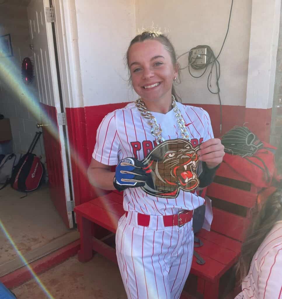 Smiling softball player holding a trophy after a game at Macon Sense.