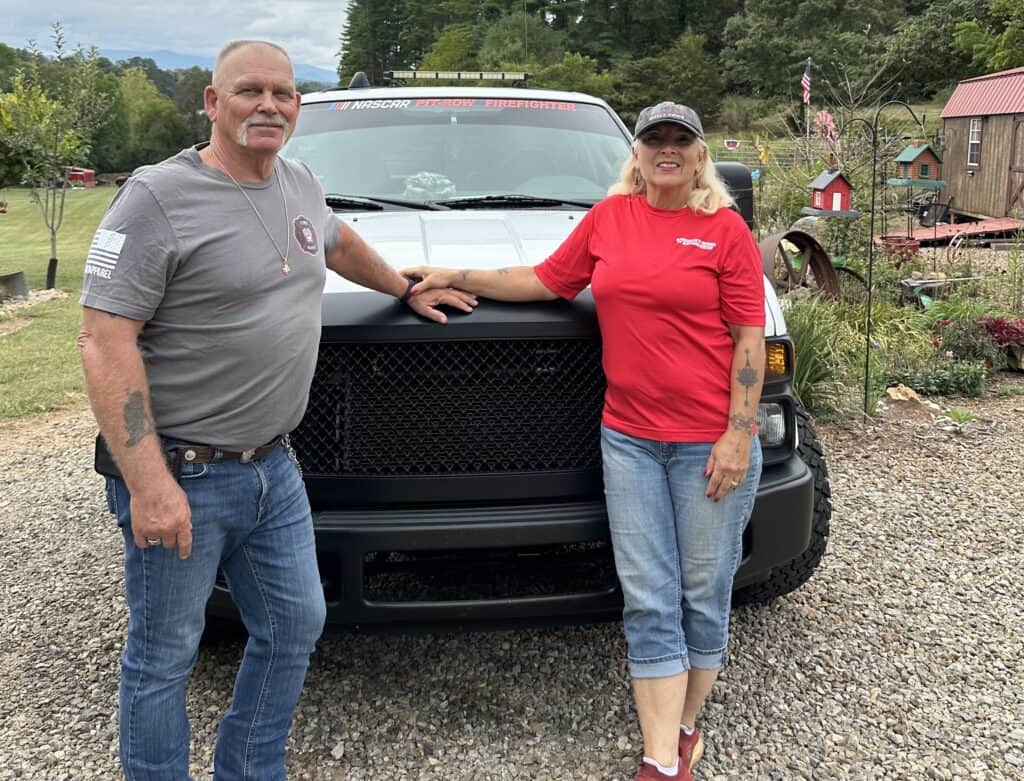 Supportive firefighter and community members with emergency vehicle.