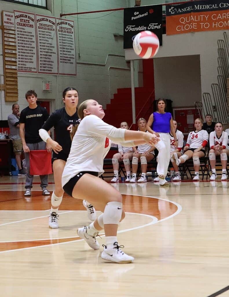 Panthers women’s volleyball player diving for the ball during match.