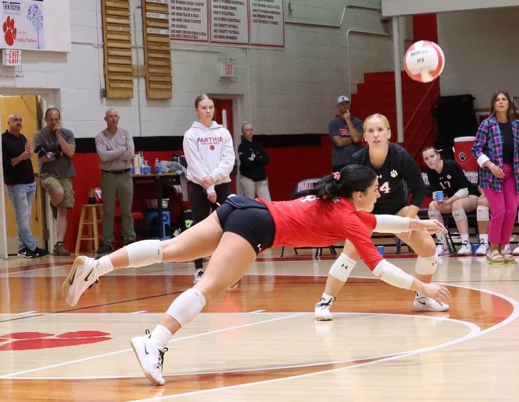 Volleyball player diving for the ball during a match at Macon Sense.