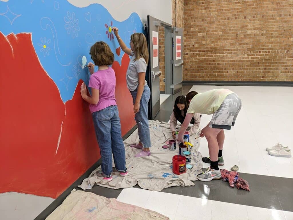Children creating colorful wall art with purpose and imagination.