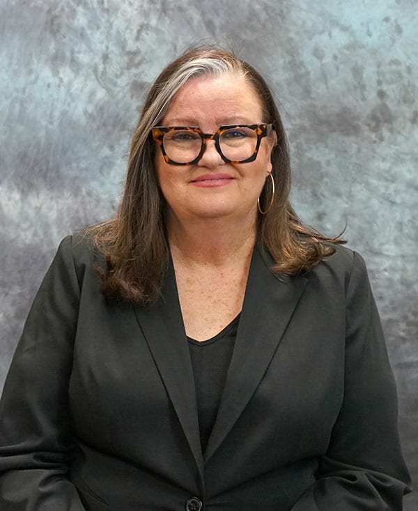 Woman speaking at seminar about avoiding financial scams, promoting awareness.