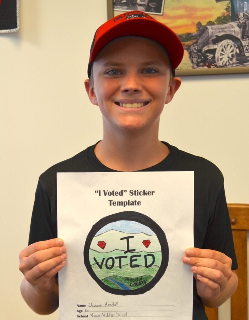 Young boy holding "I Voted" sticker template.