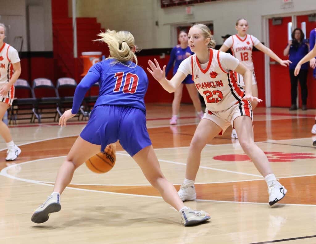 Franklin Panthers girls basketball game with intense player defense.