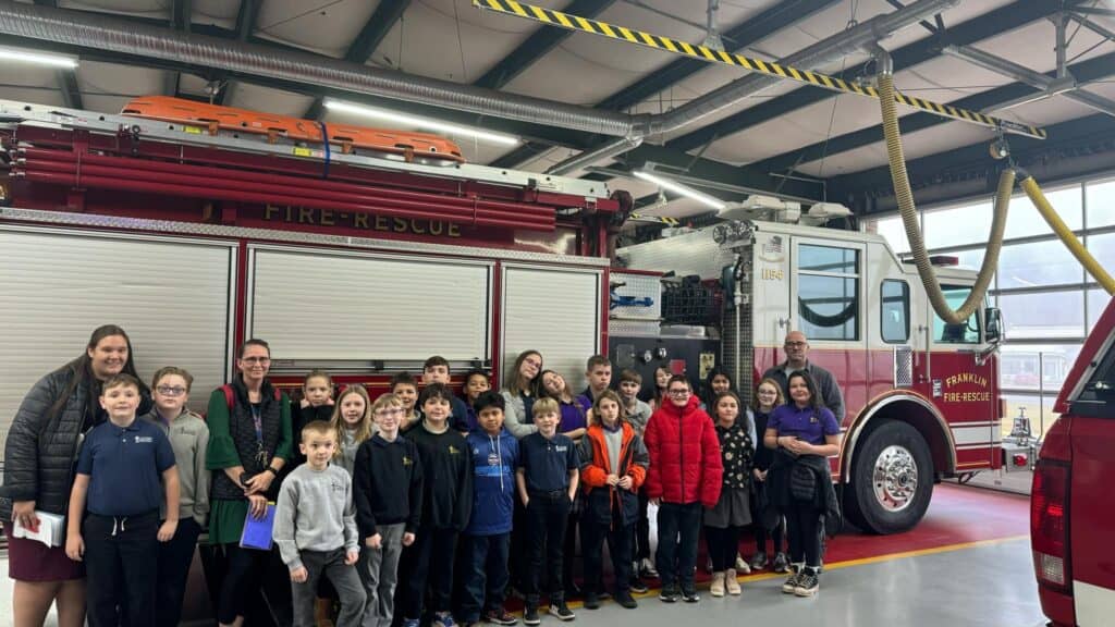 Group of fourth-graders delivering appreciation cards to firefighters at the fire station.