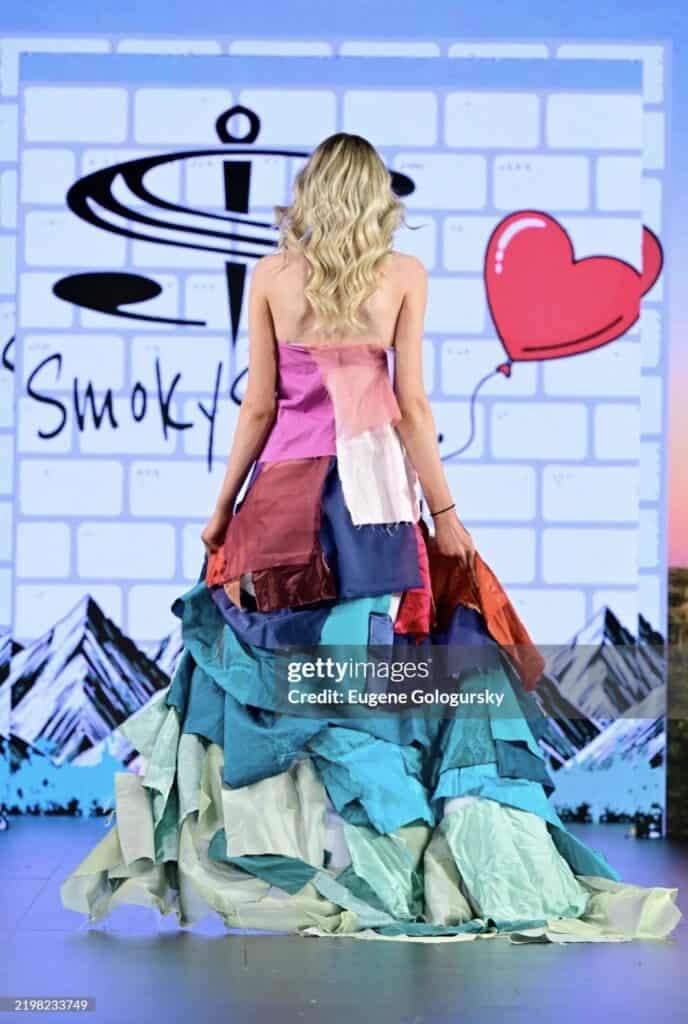 Elegant model in colorful, layered dress on runway.