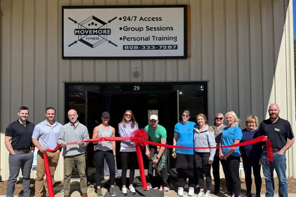 Group of diverse people celebrating grand opening at Macon Sense fitness center.