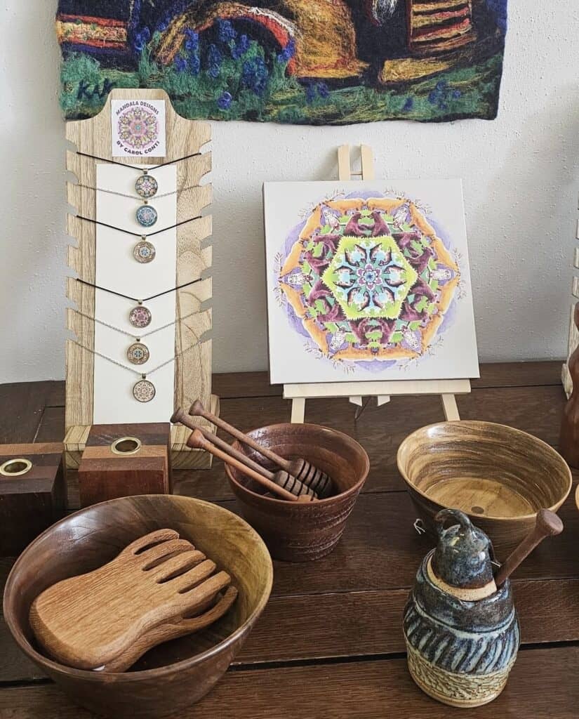 Art display featuring handmade wooden bowls and colorful artwork at Cowee School.