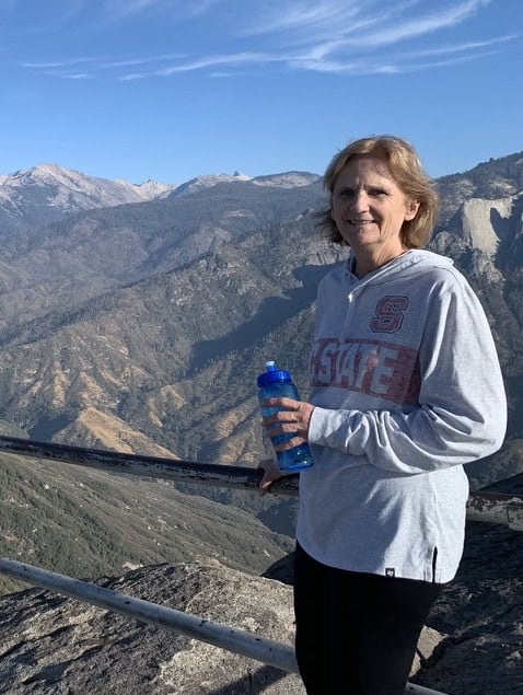 STEM teacher enjoying mountain scenery during outdoor activity.