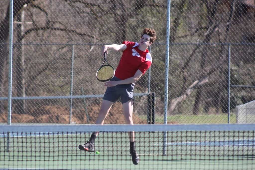 FHS Panther male tennis player hitting a shot on the court.
