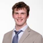 Young man smiling at graduation ceremony.