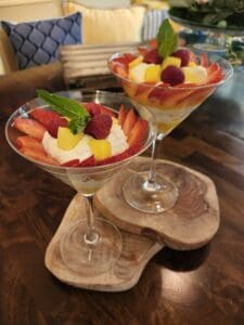 Delicious summer fruit parfaits featuring strawberries, raspberries, mango, and mint in elegant glas.