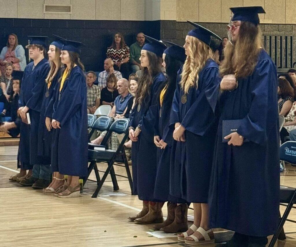 Class of 2025 graduates in caps and gowns at graduation event.