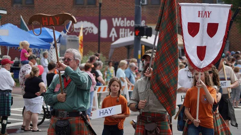 Celebrating Scottish culture with traditional attire and banners at Macon Sense event.