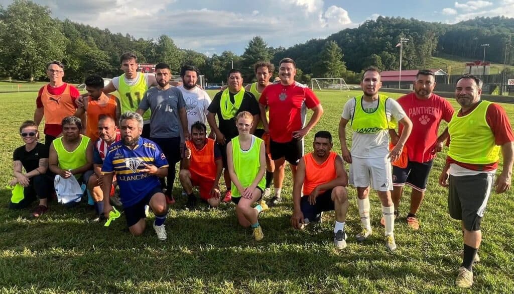 Team of diverse athletes on a soccer field, emphasizing growth and development through sports.