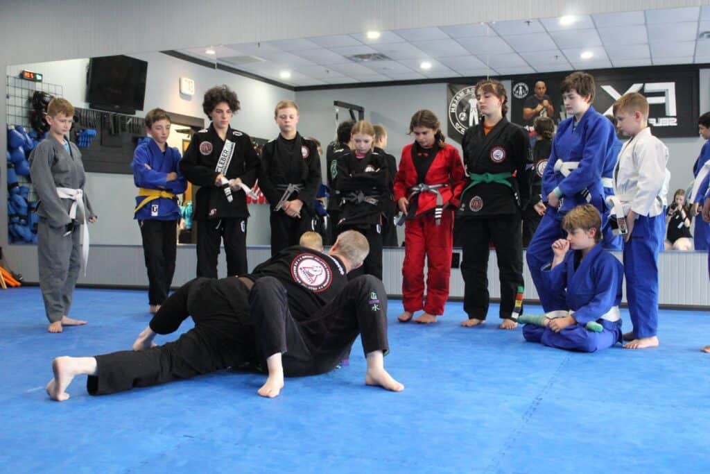Kids practicing self-defense techniques in a martial arts class at Macon Sense gym.