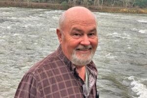 Man smiling near river during August events in Macon, Georgia.