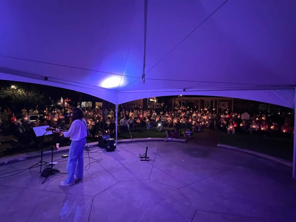 Prayer gathering at night under a large tent for America.