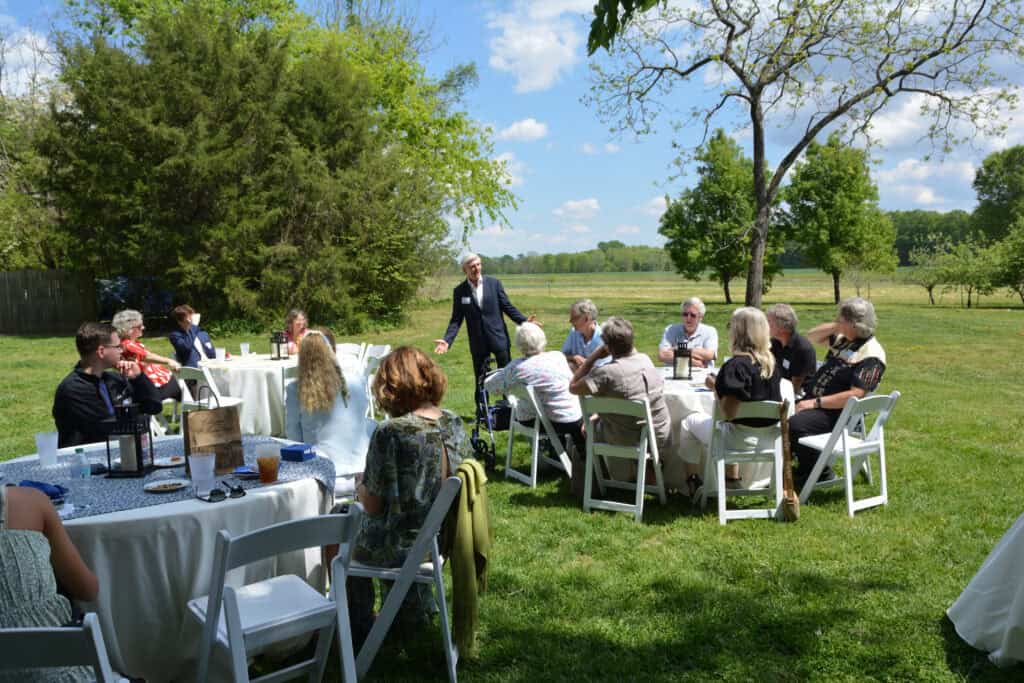 Group of people gathered outdoors for a celebration on a sunny day.