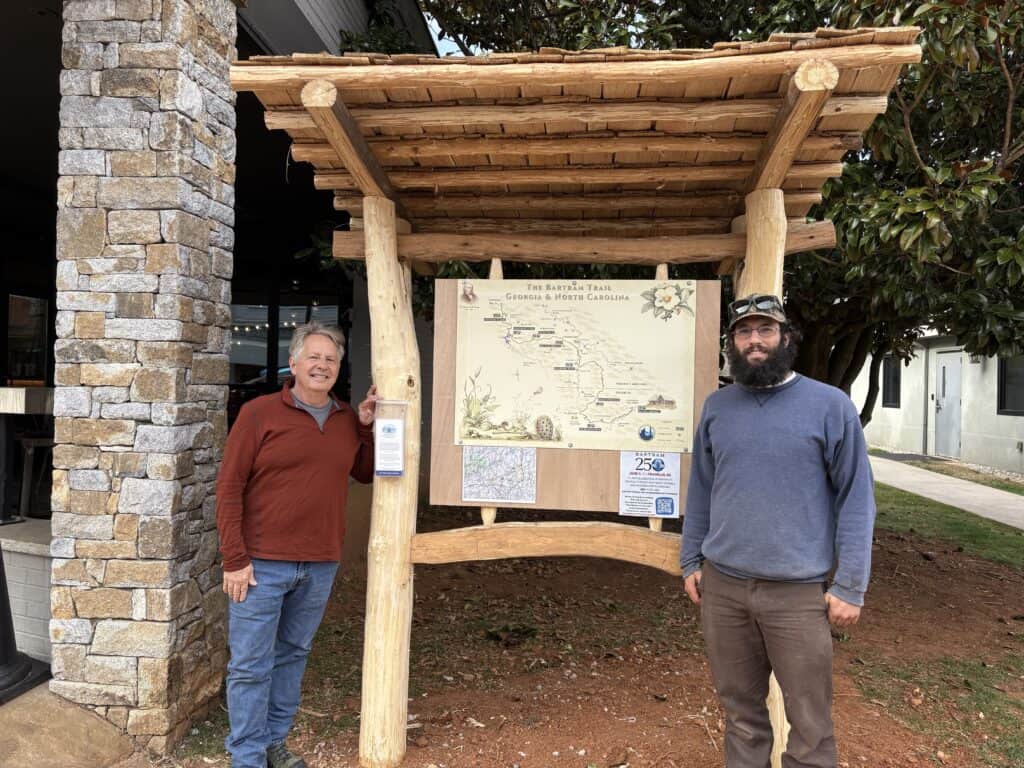 Two men standing beside a trail map sign at Bartram Trail, Georgia.