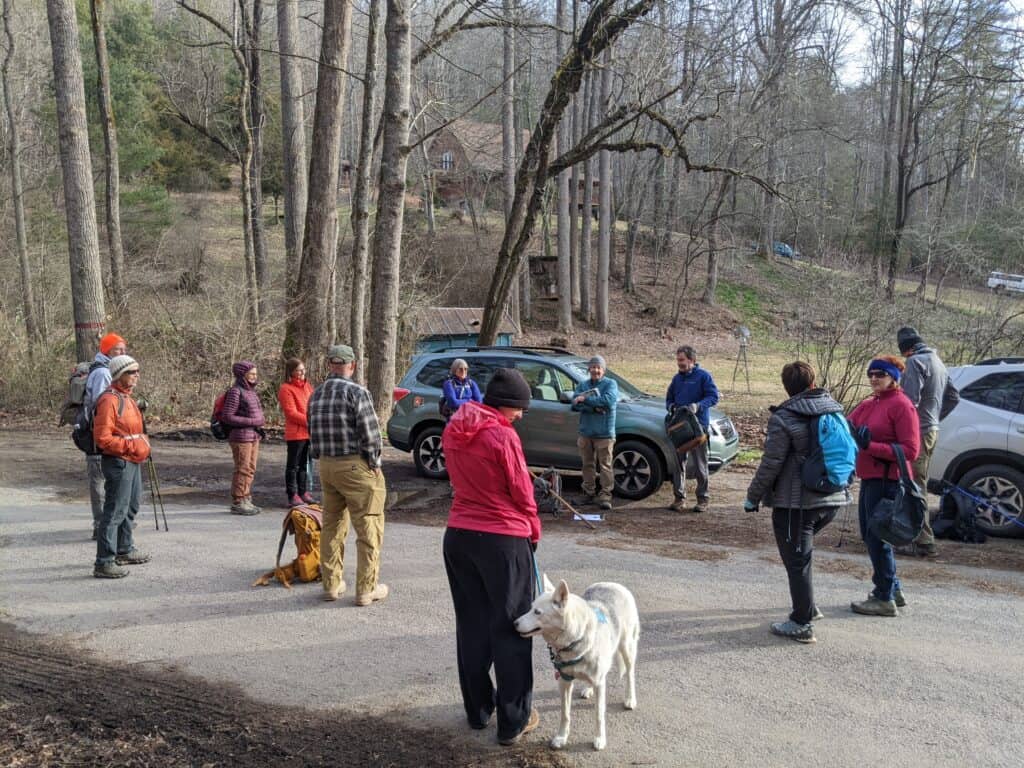 Outdoor group gathering for trail leadership farewell in a wooded area.