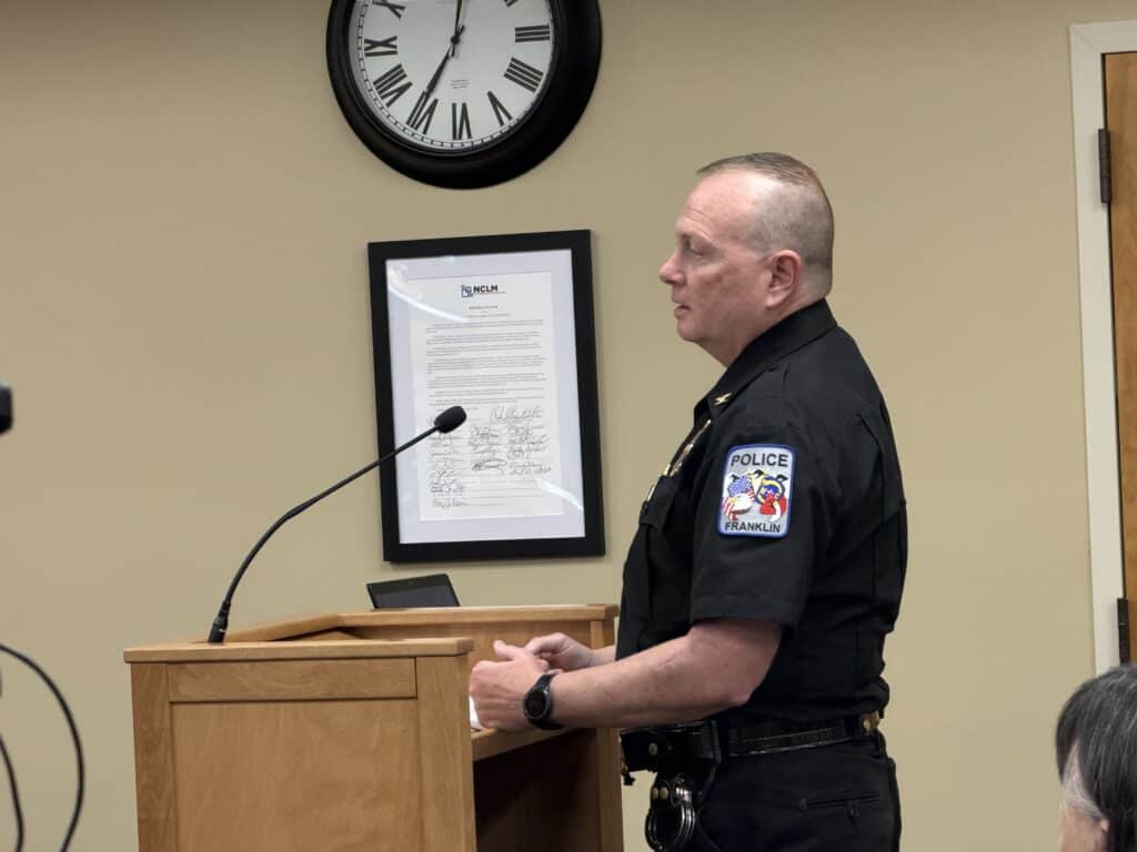 Franklin police officer speaking at downtown merchants meeting about speed enforcement.