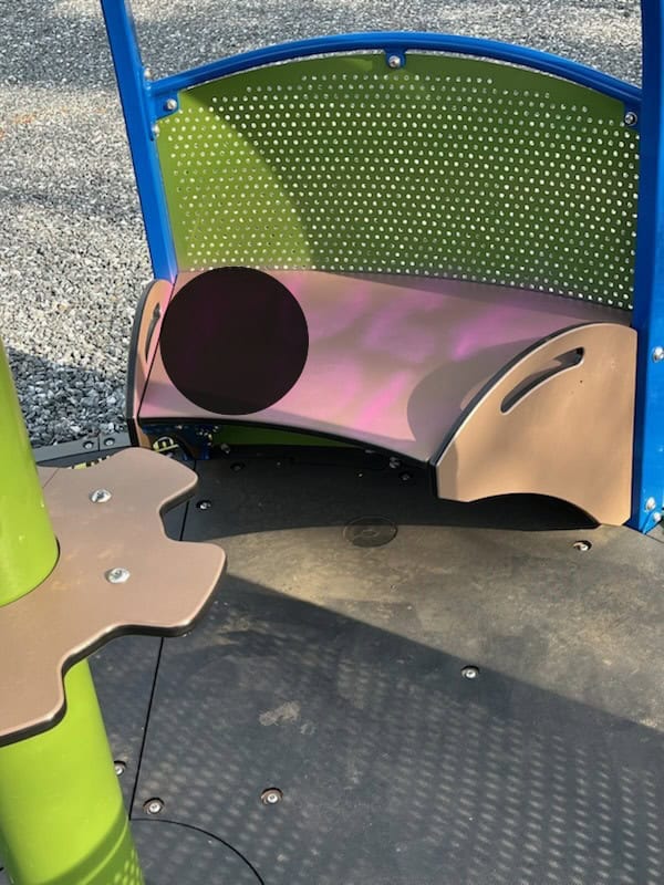 Damaged playground bench with graffiti and vandalism at Sunnyside play area.