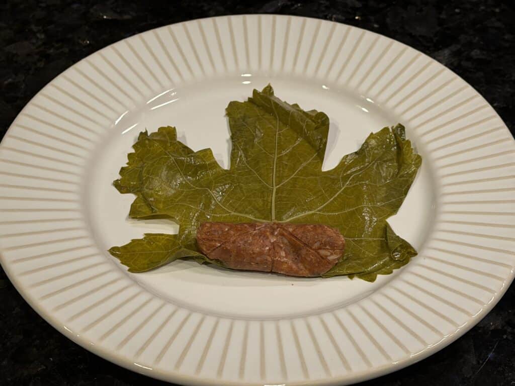 Authentic Mediterranean grape leaf roll with rice and meat filling ready to be rolled.