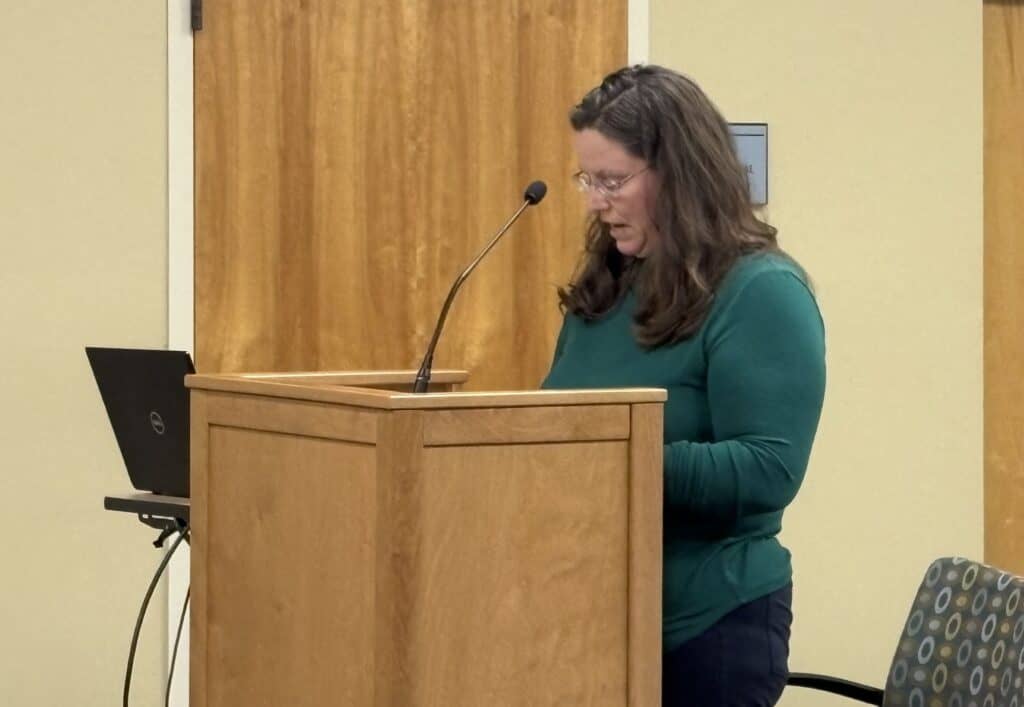 Woman speaking at a podium during downtown merchants meeting in Macon.