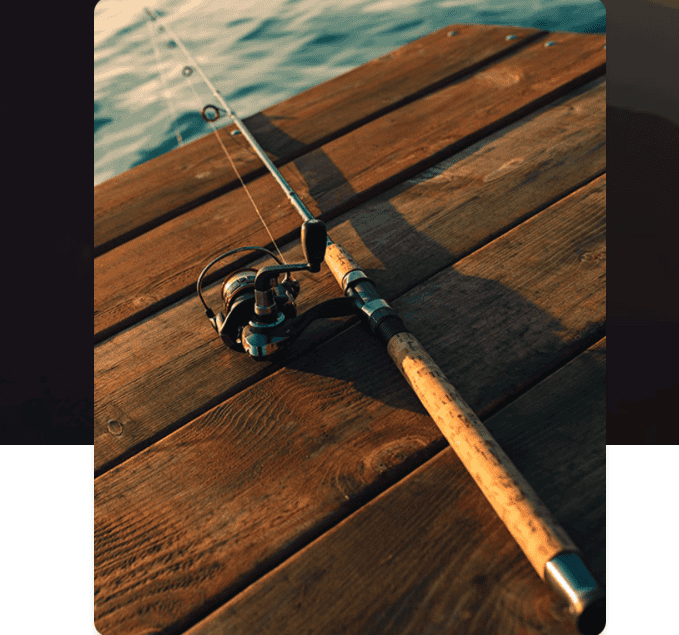 Fishing rod resting on wooden dock near water, ideal for fishing enthusiasts.